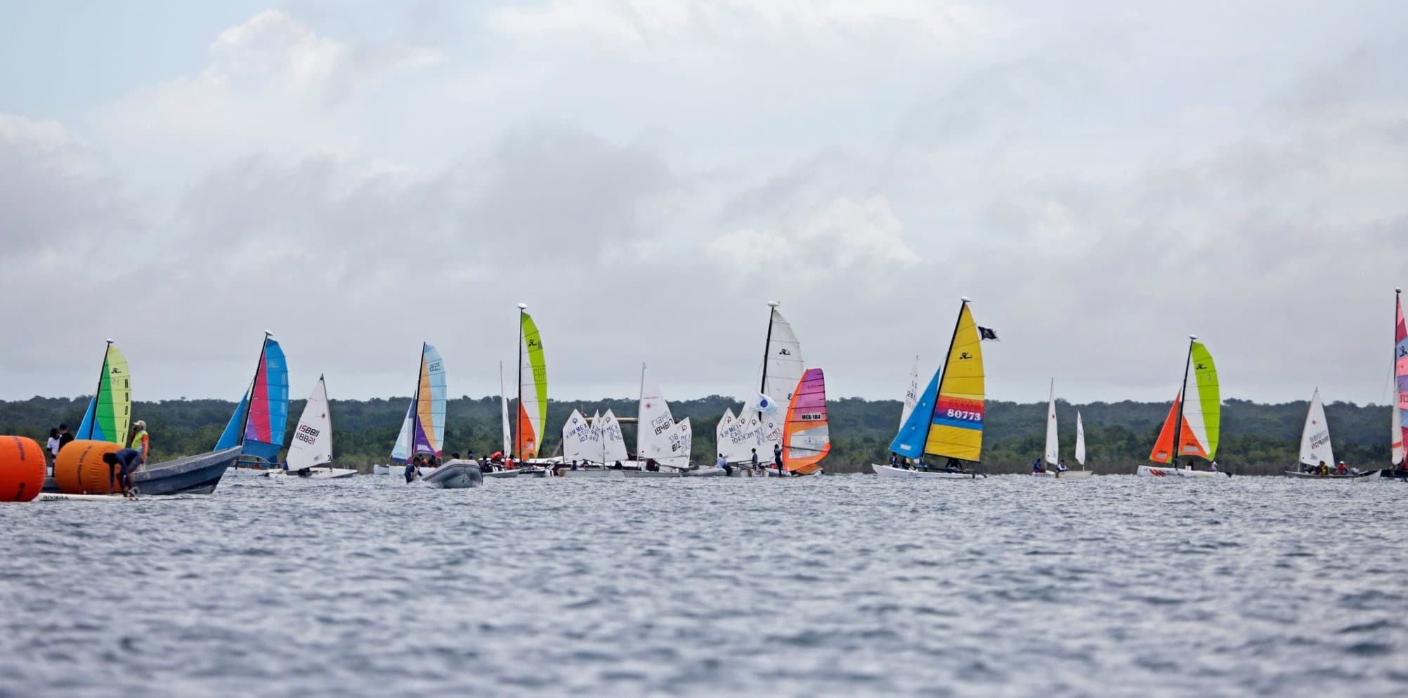 Flotte de dériveurs et de catamarans au départ d'une régate sur la lagune de Bacalar