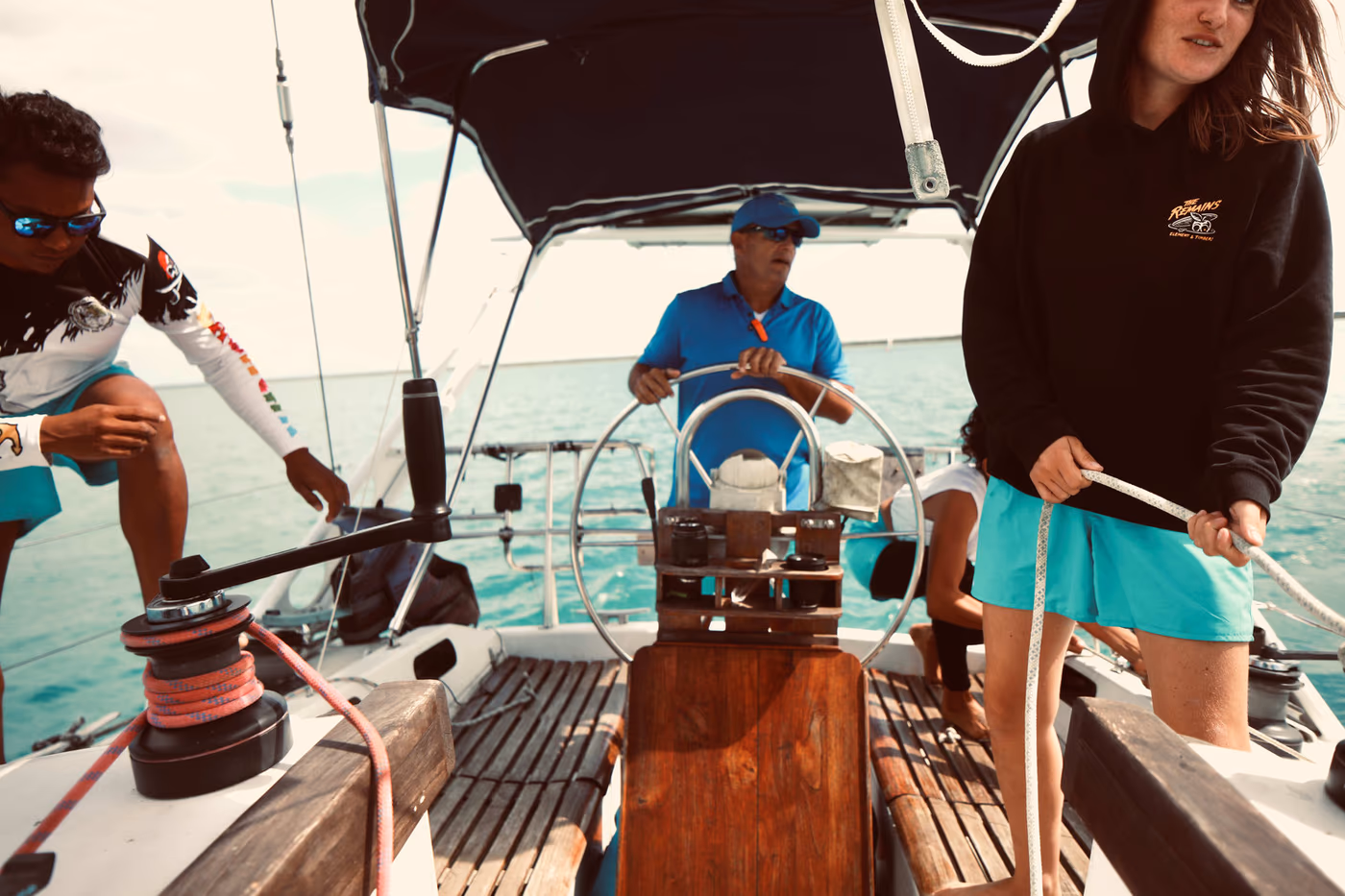 Crew working in the cockpit: helm, winch and sheet